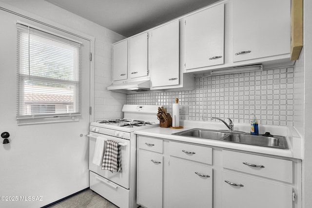 kitchen featuring backsplash, white cabinetry, sink, and gas range gas stove