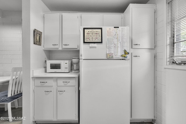 kitchen with white cabinetry and white appliances