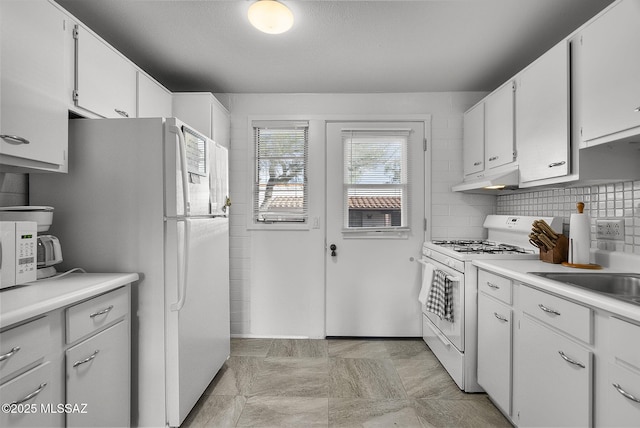 kitchen featuring white cabinets, decorative backsplash, white appliances, and sink