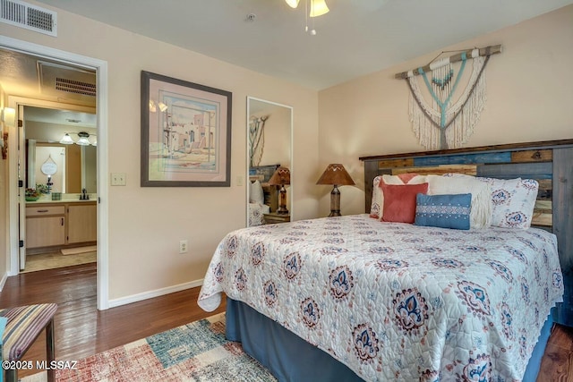 bedroom with dark hardwood / wood-style flooring, ensuite bath, and ceiling fan