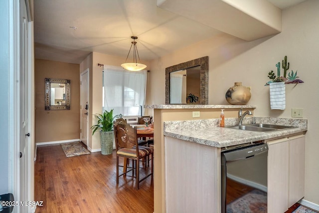 kitchen with pendant lighting, dark hardwood / wood-style floors, sink, and black dishwasher