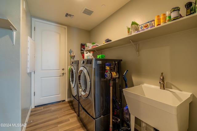 washroom featuring sink, light hardwood / wood-style flooring, and independent washer and dryer