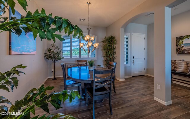 living room with wood-type flooring and ceiling fan with notable chandelier