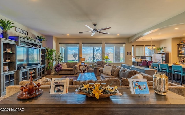 living room featuring ceiling fan with notable chandelier