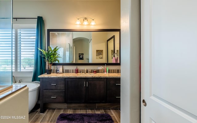 bathroom featuring vanity and a bath