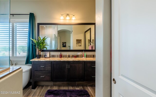 bathroom with vanity and a tub to relax in