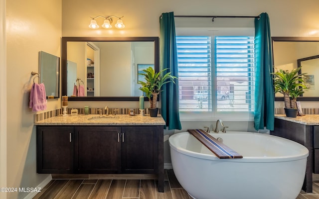 bathroom featuring vanity and a tub