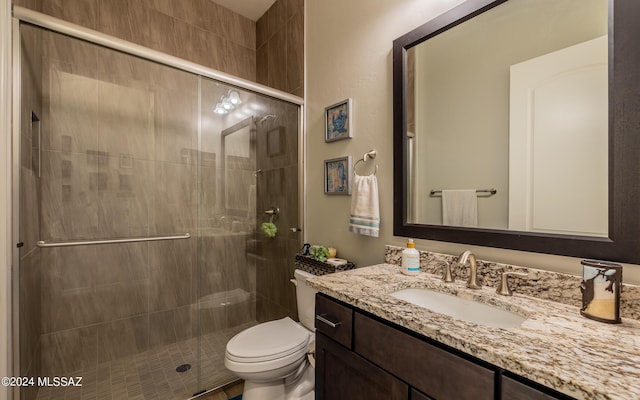 bathroom featuring vanity, toilet, and a shower with door