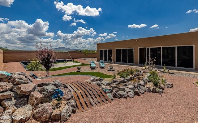 rear view of house with a mountain view and a patio