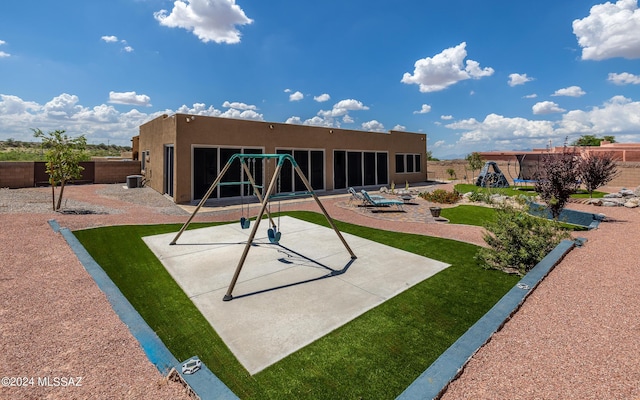 rear view of property featuring a playground