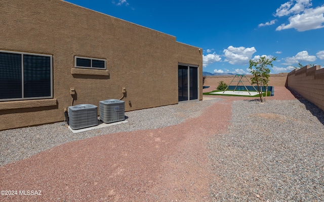 view of side of property with central air condition unit and a patio area