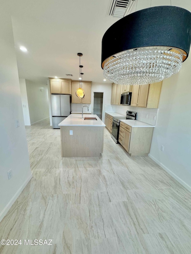 kitchen with pendant lighting, light brown cabinets, sink, an island with sink, and appliances with stainless steel finishes