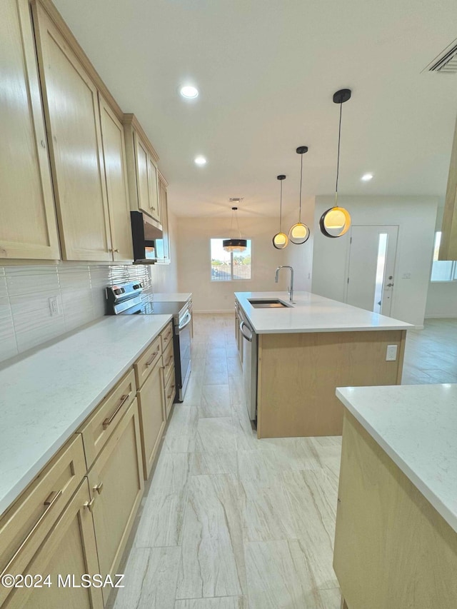 kitchen with sink, pendant lighting, a kitchen island with sink, light brown cabinetry, and appliances with stainless steel finishes