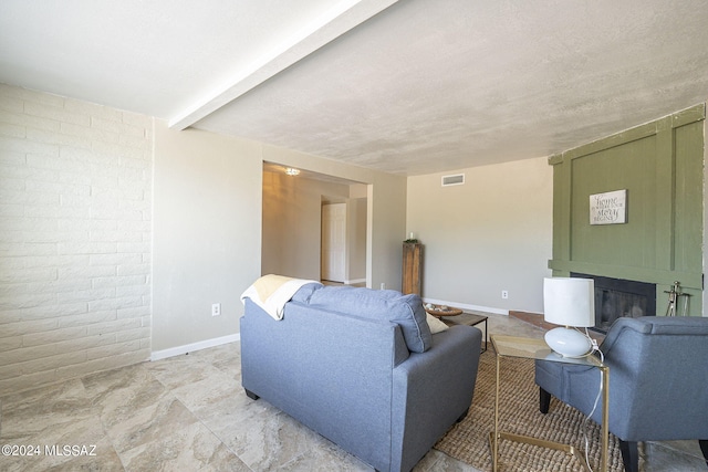 living room featuring beam ceiling and a textured ceiling