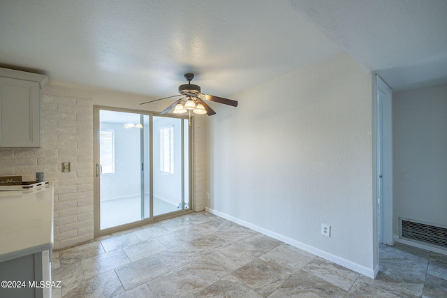 unfurnished living room featuring ceiling fan and a textured ceiling