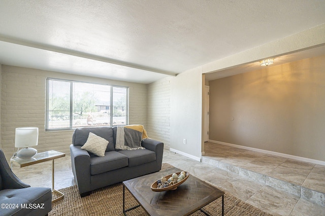 living room with a textured ceiling and brick wall