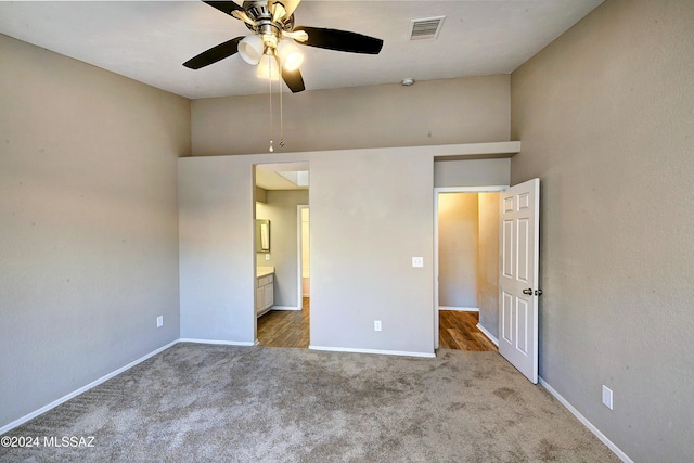 unfurnished bedroom with carpet, ensuite bathroom, and ceiling fan