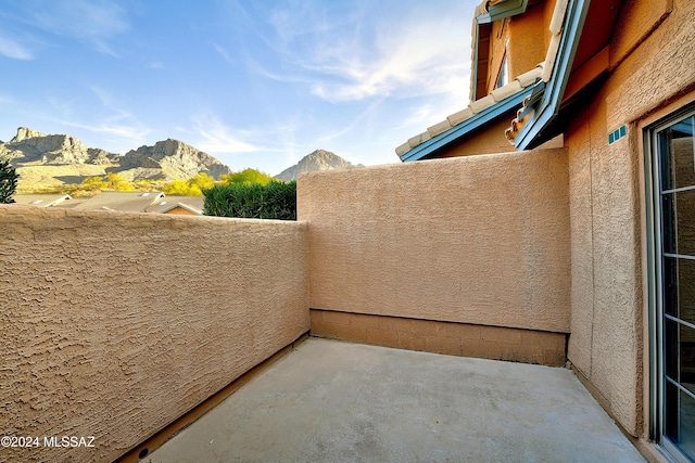 view of patio featuring a mountain view and a balcony