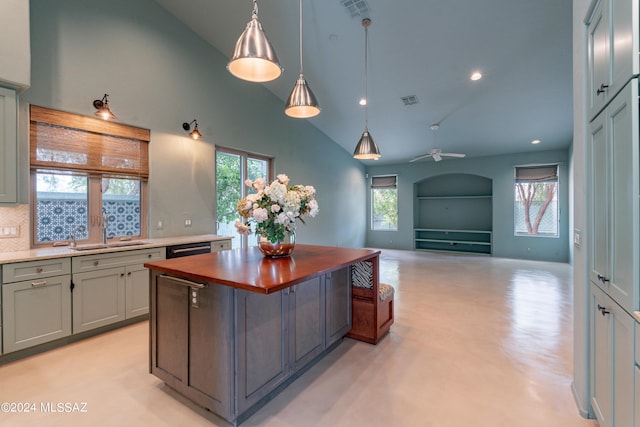 kitchen featuring pendant lighting, wooden counters, sink, ceiling fan, and tasteful backsplash