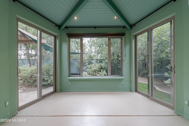 unfurnished sunroom featuring lofted ceiling with beams, a healthy amount of sunlight, and wooden ceiling