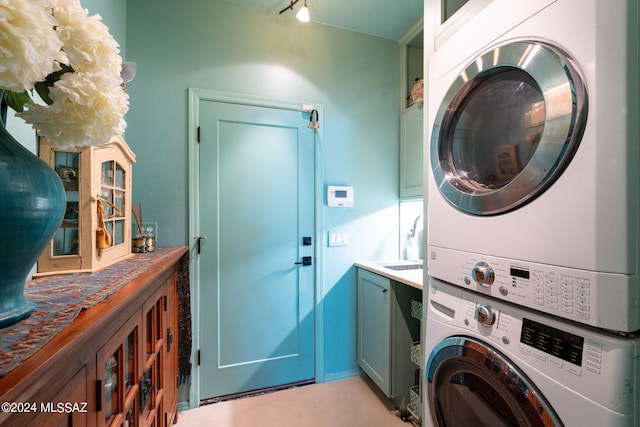 laundry area featuring cabinets and stacked washer / dryer