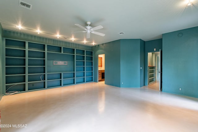 unfurnished room with built in shelves and ceiling fan