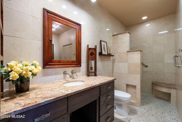 bathroom featuring an enclosed shower, vanity, toilet, and tile walls