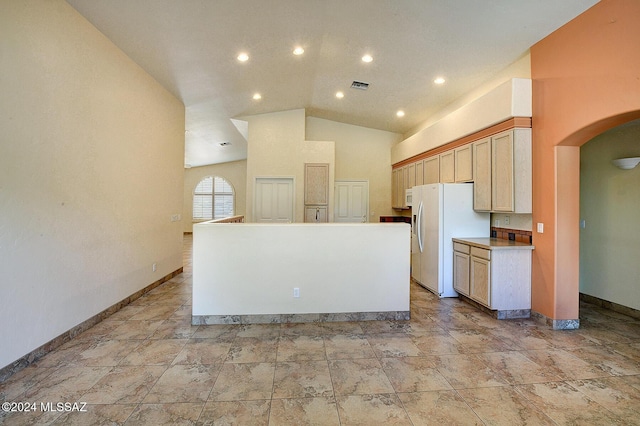 kitchen featuring a kitchen island, white refrigerator with ice dispenser, light brown cabinets, and high vaulted ceiling