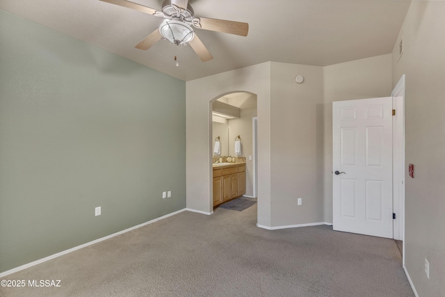 unfurnished bedroom with connected bathroom, ceiling fan, sink, and light colored carpet