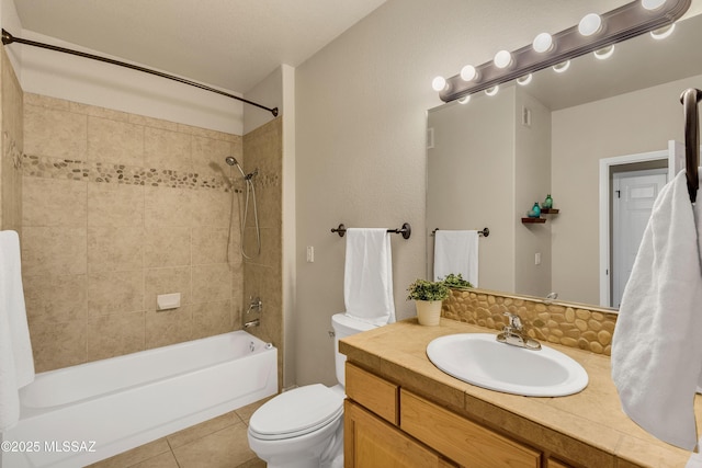 full bathroom featuring tile patterned floors, vanity, tiled shower / bath, and toilet