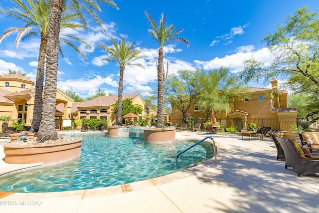 view of swimming pool with a jacuzzi and a patio