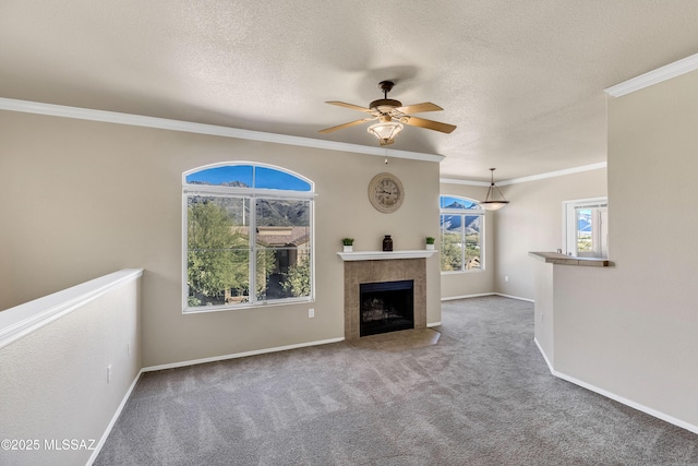 unfurnished living room with ceiling fan, carpet, a textured ceiling, and ornamental molding