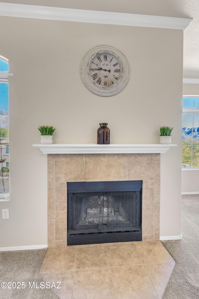 details featuring ornamental molding, carpet floors, and a tile fireplace