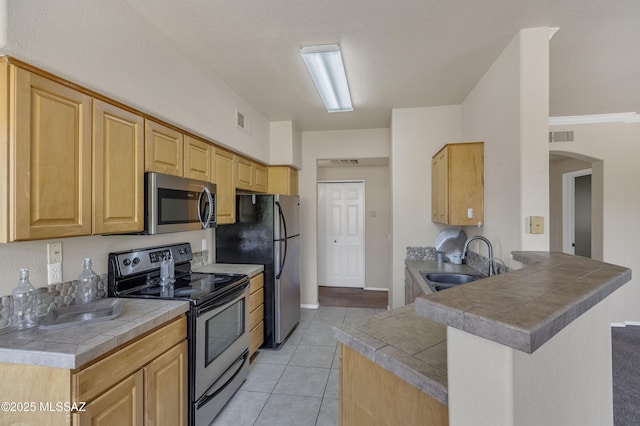 kitchen featuring tile counters, sink, stainless steel appliances, kitchen peninsula, and light tile patterned floors