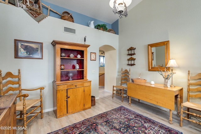 interior space with an inviting chandelier, light hardwood / wood-style flooring, and high vaulted ceiling