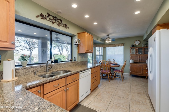 kitchen with sink, light tile patterned floors, ceiling fan, light stone counters, and white appliances