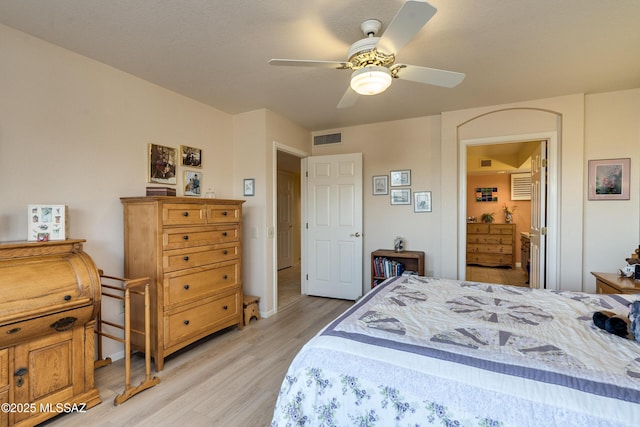 bedroom featuring ceiling fan, light hardwood / wood-style floors, and ensuite bath