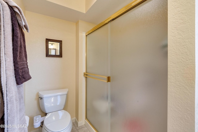 bathroom with an enclosed shower, tile patterned flooring, and toilet