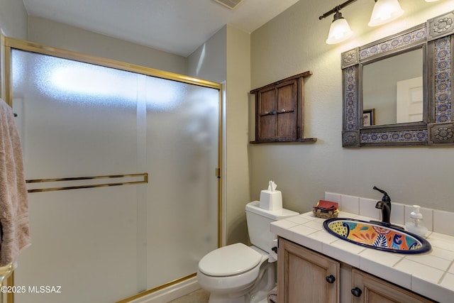 bathroom featuring vanity, toilet, and a shower with door