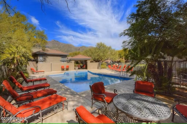 view of swimming pool with a mountain view and a patio