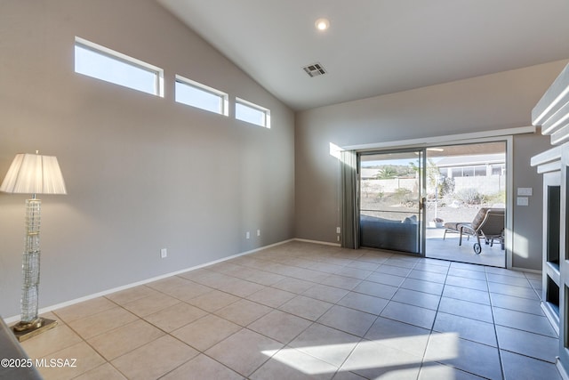 empty room with light tile patterned floors and high vaulted ceiling