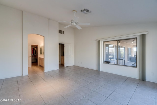 tiled spare room featuring ceiling fan and vaulted ceiling