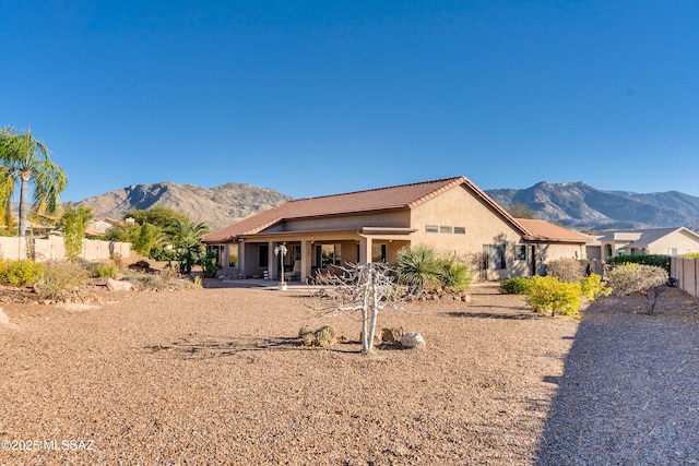 back of property with a patio area and a mountain view