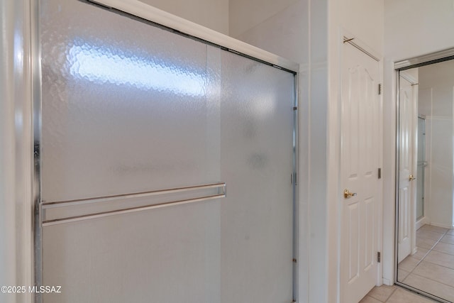 bathroom with tile patterned flooring and a shower with shower door