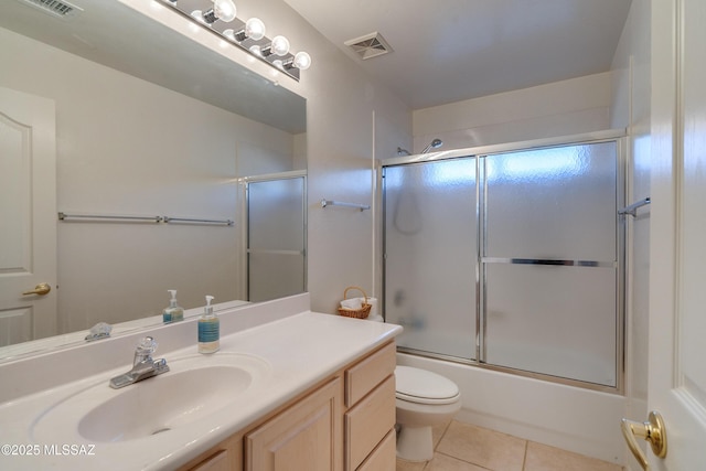 full bathroom featuring shower / bath combination with glass door, tile patterned floors, vanity, and toilet