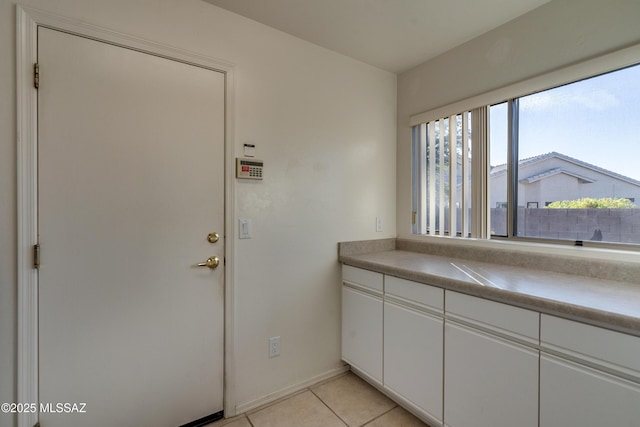 interior space featuring white cabinetry and light tile patterned floors