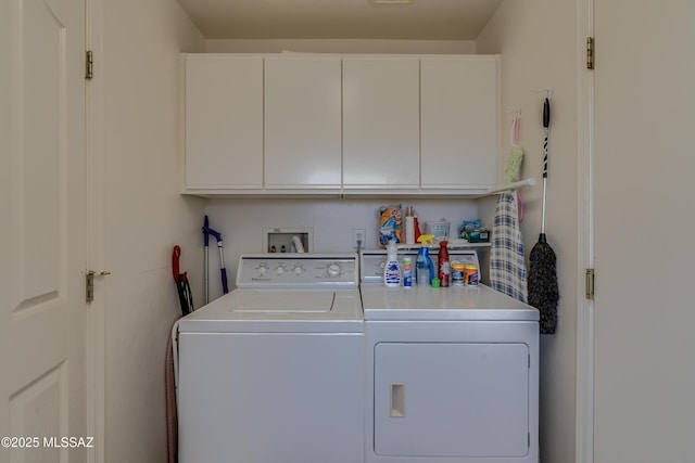 laundry area featuring washing machine and clothes dryer and cabinets