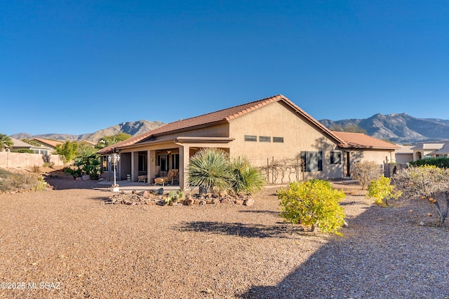 rear view of property with a mountain view and a patio