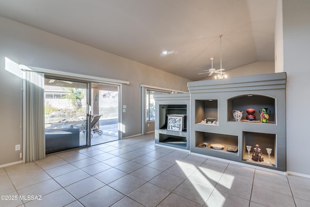 unfurnished living room with a notable chandelier, light tile patterned floors, built in shelves, and vaulted ceiling