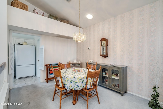 dining room with a chandelier and light colored carpet